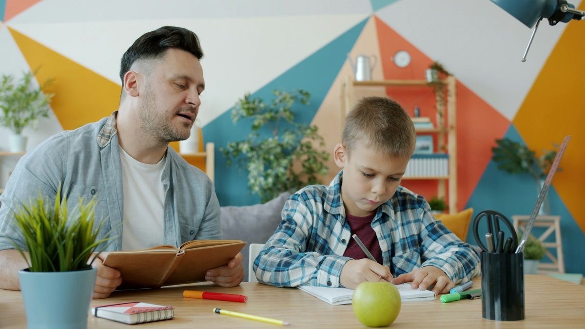 机に向かい学習を共にする親子の姿